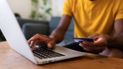 Unrecognisable African American man using laptop and credit card to buy things online